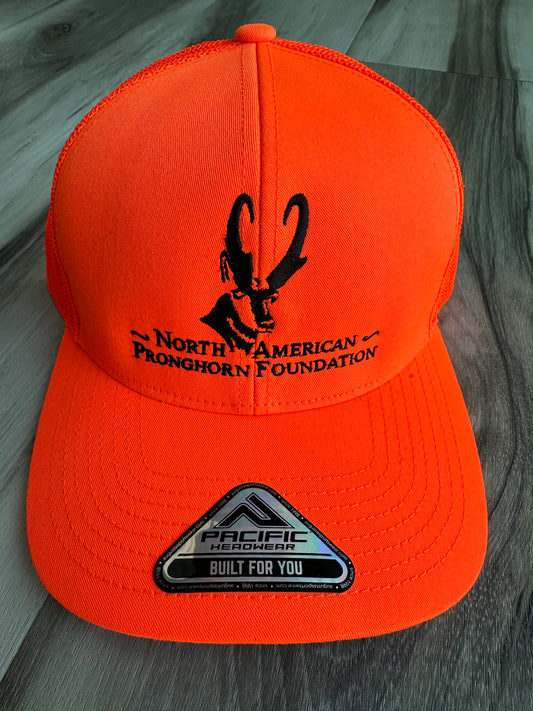 Orange cap with black logo and text on a wooden surface